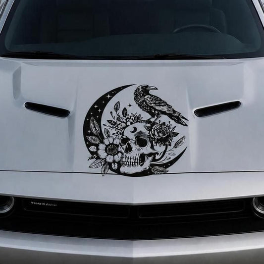 Black raven perched on crescent moon with floral skull vinyl hood decal on silver car