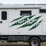 Green claw mark mountain and pine tree vinyl decal displayed on a white Camper