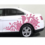 Pink cobra snake and flower vine vinyl decal on the side door of a white sedan