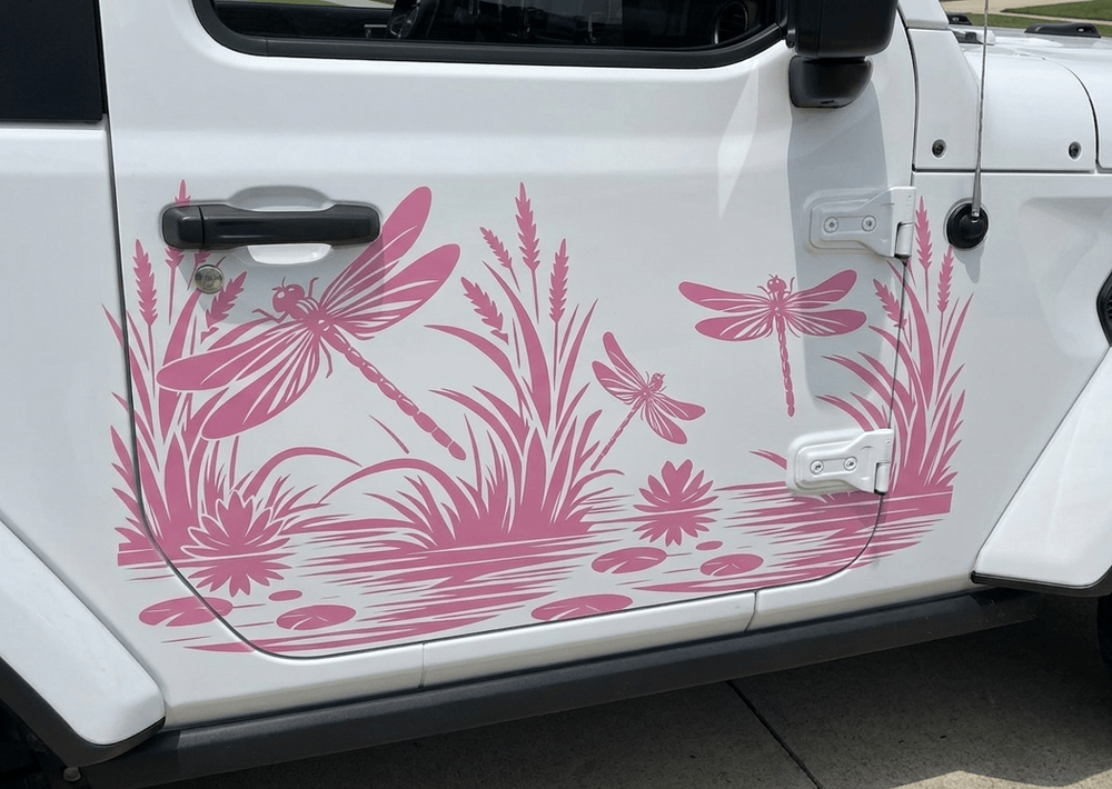 Pink dragonfly and reeds vinyl decal applied to the side door of a white vehicle.