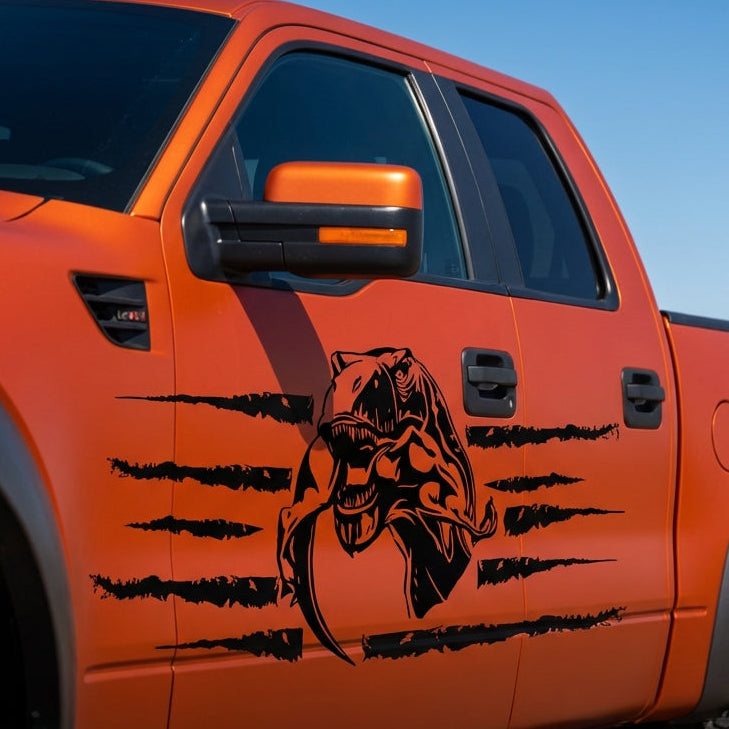 T‑Rex eating raptor vinyl car decal, black on orange truck bedside, die‑cut with no background”