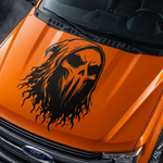 Black ghost skull with flowing flame design vinyl decal displayed on an orange truck hood
