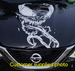 “Venom‑inspired vinyl hood decal in white, applied on a black car, die‑cut with no background”