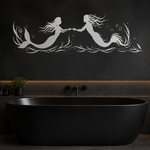 A modern freestanding black bathtub in a dark, minimalist bathroom with a black wall featuring a white mermaid  and merman silhouette design above the tub.