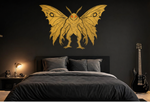 Gold Mothman vinyl wall decal above a bed on a dark bedroom wall