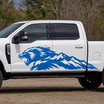 Blue Mountain Beast decal, a roaring beast head blending into a mountain range, on the side of a white pickup truck