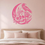 Pink raven perched on crescent moon with floral skull on interior wall
