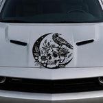 Black raven perched on crescent moon with floral skull vinyl hood decal on silver car