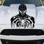 A black Spider-Man decal applied to the hood of a white car, shown from the front in an outdoor setting.