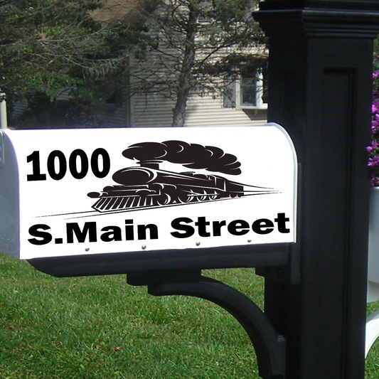 Black mailbox post with white mailbox displaying '1000 S. Main Street' in a garden setting.