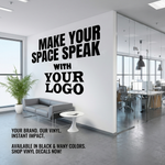 A large black vinyl wall decal mockup displayed on a white office wall. The text reads 'MAKE YOUR SPACE SPEAK WITH YOUR LOGO