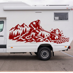 A white motorhome or camper van parked outdoors on a paved lot, featuring a large red sasquatch/bigfoot vinyl decal with a mountain background on the side of the motorhome