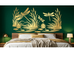 A bed in a styled bedroom with a dark green wall behind it, featuring a large gold-toned wall art piece depicting dragonflies, reeds, and water lilies above the headboard.