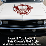 White car with Pennywise inspired clown vinyl decal on the hood, parked in an outdoor setting.