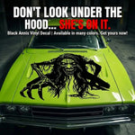 “Zombie/Banshee ‘Black Annis’ vinyl hood decal, white, die‑cut with no background on green car”