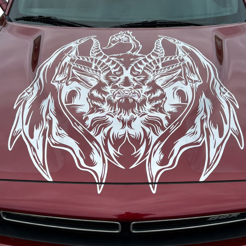 Muscle car with a large silver chimera creature decal featuring lion, goat, and serpent elements displayed across the hood

