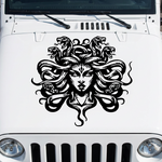 White Jeep with a Medusa head vinyl decal on the hood