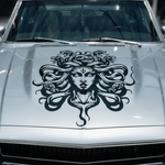 White Jeep with a Medusa head vinyl decal on the hood
