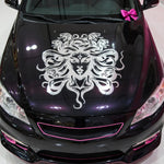 Black car with a white medusa design on the hood, decorated with pink bows on a white background.