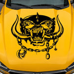 Yellow muscle car with aggressive war pig skull hood decal featuring tusks and chain design