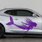 A silver sports coupe shown in side profile on a neutral indoor studio floor, featuring a large purple mermaid vinyl decal running along the side door.