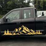Gold mountain range and pine tree side decal on a black Ford F-150 pickup truck