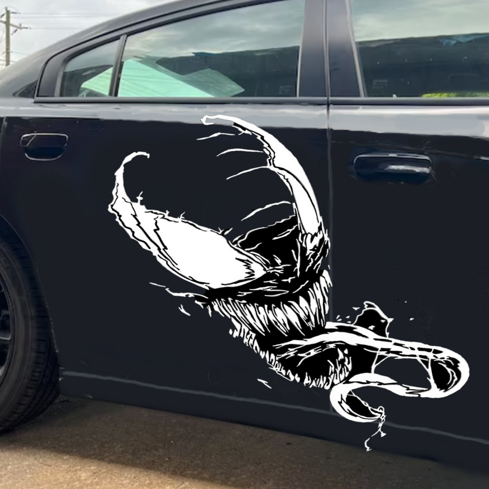 “Venom‑inspired vinyl hood decal in white, applied on a black car, die‑cut with no background”