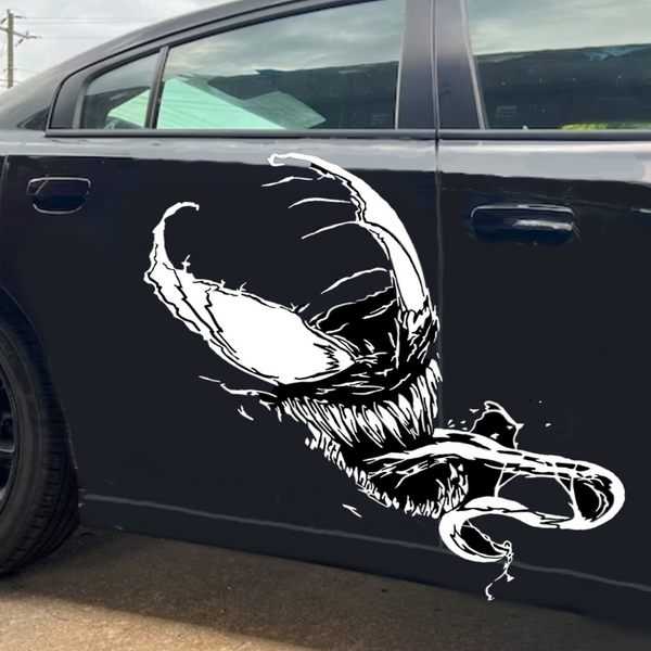 “Venom‑inspired vinyl hood decal in white, applied on a black car, die‑cut with no background”