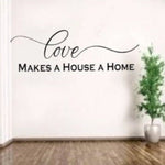 “Love Makes a House a Home" vinyl wall decal in matte black, 40×10, applied to smooth painted wall”