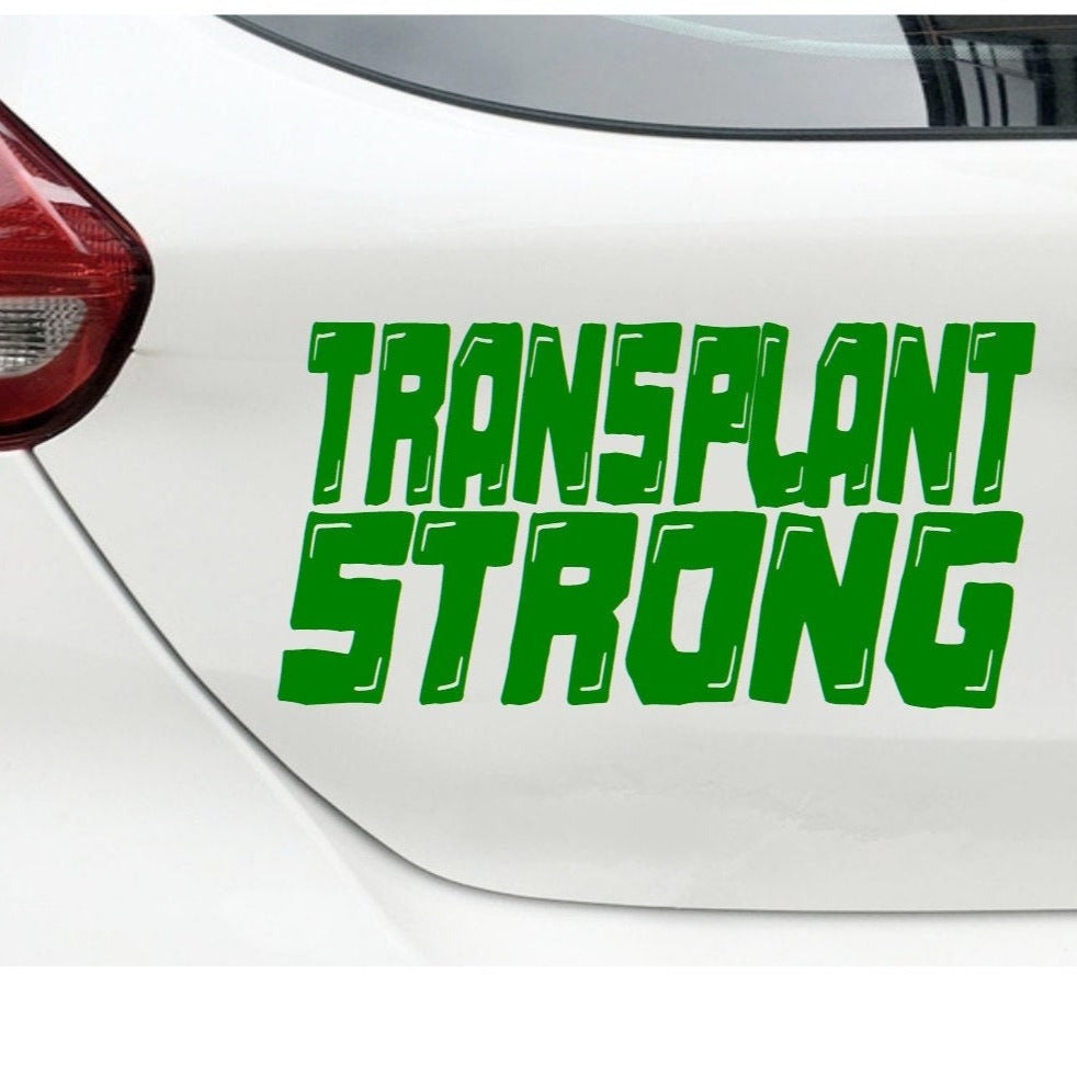 “Transplant Strong" vinyl car window decal, green 9‑inch width, die‑cut with no background on tinted rear glass
