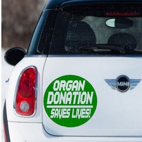 “Organ Donation Saves Lives" vinyl car window decal, white, 11‑inch width, die‑cut with no background on tinted glass